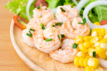 Shrimp salad with corn,green oak, onion and tomato in wooden dish.