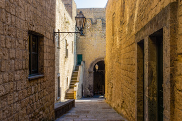 Fototapeta na wymiar Narrow way or street between walls of buildings in Castel
