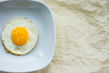 Round fried egg in the plate.