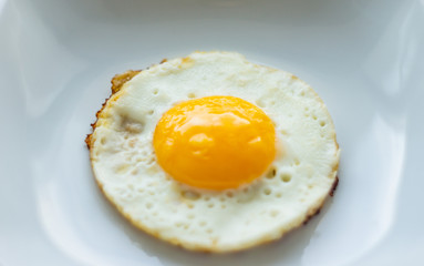 Round fried egg in the plate.