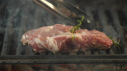 Closeup of a grilled steak cooked with a sprig of rosemary