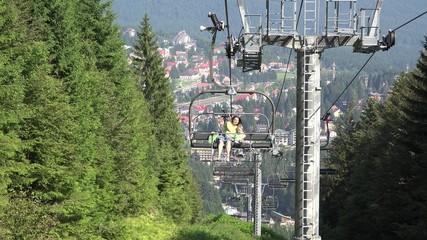 Mother holding little child in chairlift, spring adventure