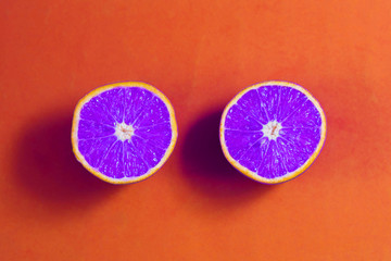 Bright purple oranges in cut on orange background