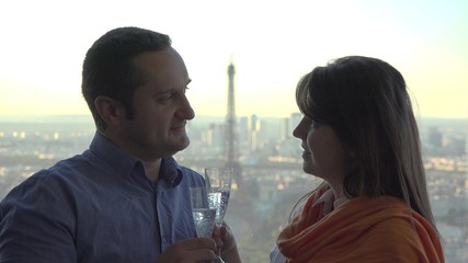 Romantic celebration, man and woman with champagne glasses, Eiffel tower in background