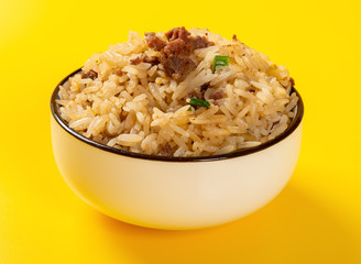 fried rice with beef in a bowl on yellow background close up