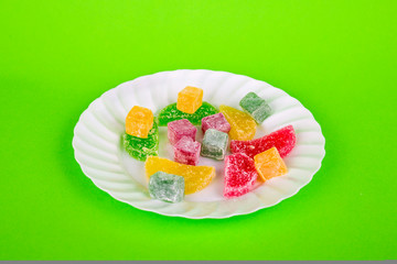 Marmalade and delight on a green background. Turkish sweets Multi-colored marmalade. Sweet fruit lemon marmalade. Jelly candies. Eastern sweets. Turkish delicacies