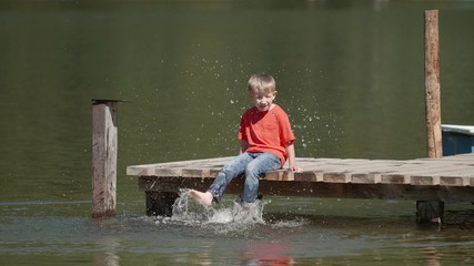 Slow motion berefoot kid on pontoon hit the water with feet