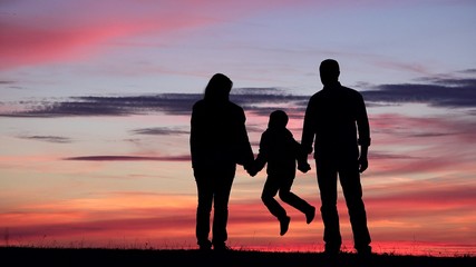 Family silhouettes portrait at sunset, parent and child hold hands, invincible team