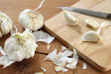 garlic on wooden cutting board with knife