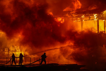 Firefighters spraying high pressure water to burning house.  Conflagration. Ukraine.