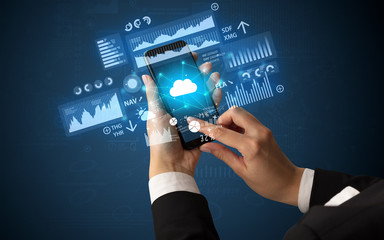 Female hand using smartphone with financial tracking concept illustrated by graphs and symbols