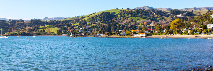 Fototapeta na wymiar Panoramic photo of the harbourside in the French settlement town of Akaroa in the South Island of New Zealand.
