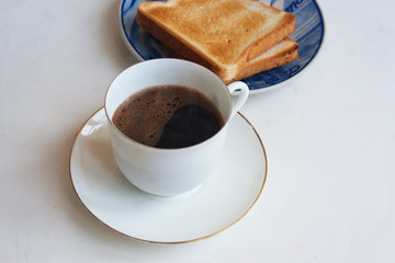 A cup of coffee with toaster bread. Candid.