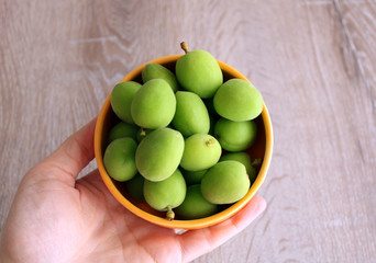 Green apricots in the spring, fresh fruits, top view in the bowl