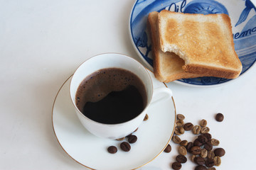 A cup of coffee with toaster bread, beans coffee. Candid.