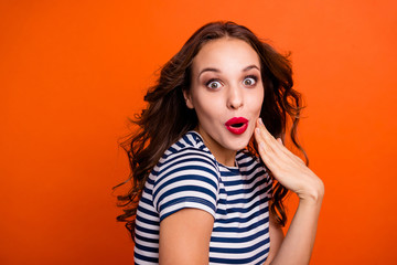 Closeup photo headshot photo portrait of charming cheerful with strange facial expression she her lady with flying hairdo holding hand near mouth isolated vibrant background