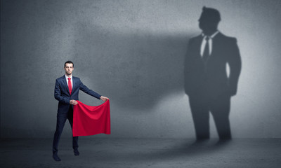 Businessman standing with red cloth on his hand and his shadow on the background
