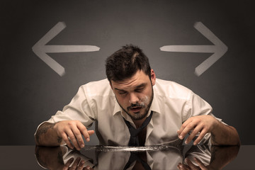 Drunk disappointed man sitting at table with arrows around
