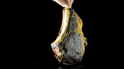T-bone steak grilled to its fullest unfolded in half turn on an isolated black background