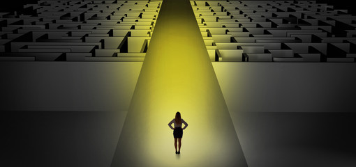 Woman going straight ahead on a wide road between dark mazes

