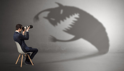 Young businessman staying and  negotiate with a monster shadow
