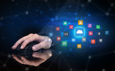 Hand using wireless mouse in a dark environment with cloud technology and online storage concept