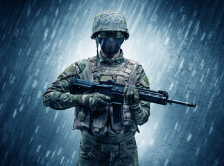 Armed soldier standing in rainy weather
