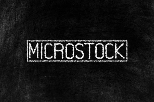 Microstock in Chalk Hand Writing on Old Grunge Chalkboard Background, Suitable for Education and Business Concept.
