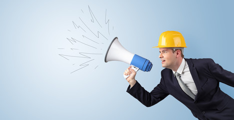 Fototapeta premium Young architect constructor yelling with megaphone and copyspace 
