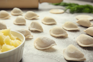 Fototapeta na wymiar Raw dumplings on grey table, closeup. Process of cooking