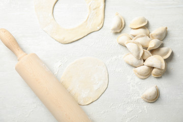 Flat lay composition with raw dumplings on light background. Process of cooking