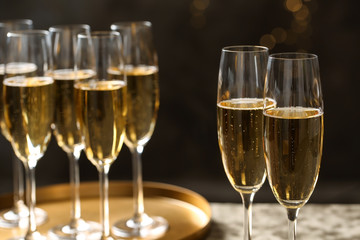 Glasses of champagne on blurred background, closeup. Space for text