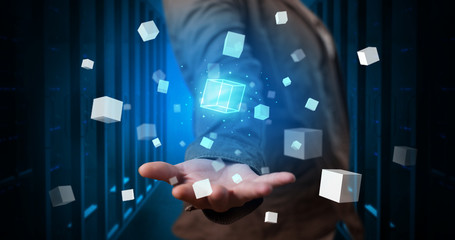 Person holding hologram projection displaying white cubes in server room
