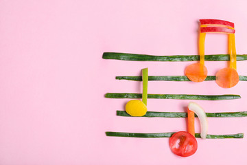 Musical notes made of fruits and vegetables on color background, top view. Space for text
