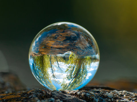 Landscape reflected in a crystal ball on an old wooden table