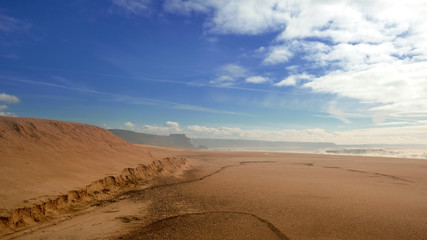 Fototapeta na wymiar Wide deserted beach on the Atlantic coast in the town of Nazare Portugal
