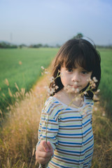 Adorable little girl playing in the wheat field 