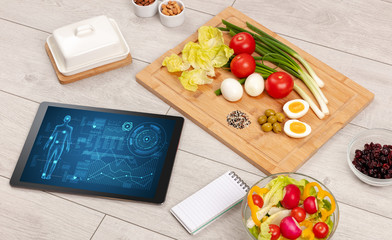 Healthy food composition with tablet. Body diagnosis on the screen