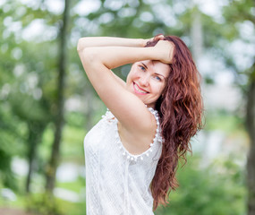 Portrait of cute young caucasian woman in nice white dress in the summer park. Beautiful natural background (bokeh).