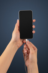 Close-up view of hand charging smartphone