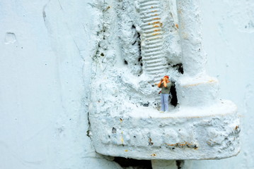 Close up Miniature People, Photographer Standing on Grunge Concrete Wall Background.