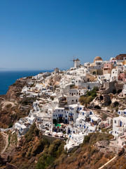 Oia village on the island of Santorini Greece is well known for its collection of white washed terraced apartments climbing up the side of the rock face.  