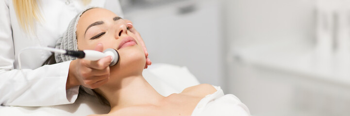 Fototapeta Beautiful woman in professional beauty salon during photo rejuvenation procedure obraz