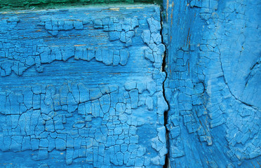 Old wooden background with remains of pieces of scraps of old paint on wood. Texture of an old tree, vintage wood background peeling paint. old blue board with cracked paint