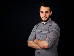 portrait of a young man with a beard on a black background