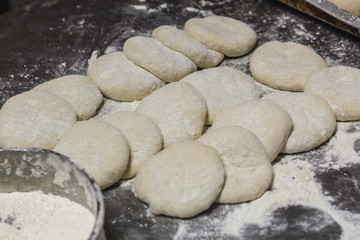 Fototapeta na wymiar Raw dough on the backery table. Preparing bread dough for backing bread. Food preparing concept