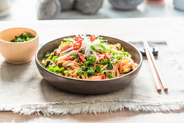 Traditional chinese vegetarian noodle chow mein on a plate with chopsticks