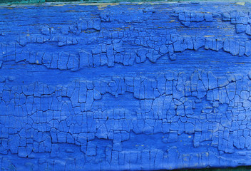 Old wooden background with remains of pieces of scraps of old paint on wood. Texture of an old tree, vintage wood background peeling paint. old blue board with cracked paint