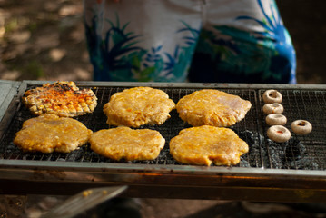 A shot of some of burgeres on iron bbq /oven and mushrooms getti