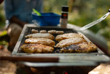 A shot of some of burgeres on iron bbq /oven and beside cooking